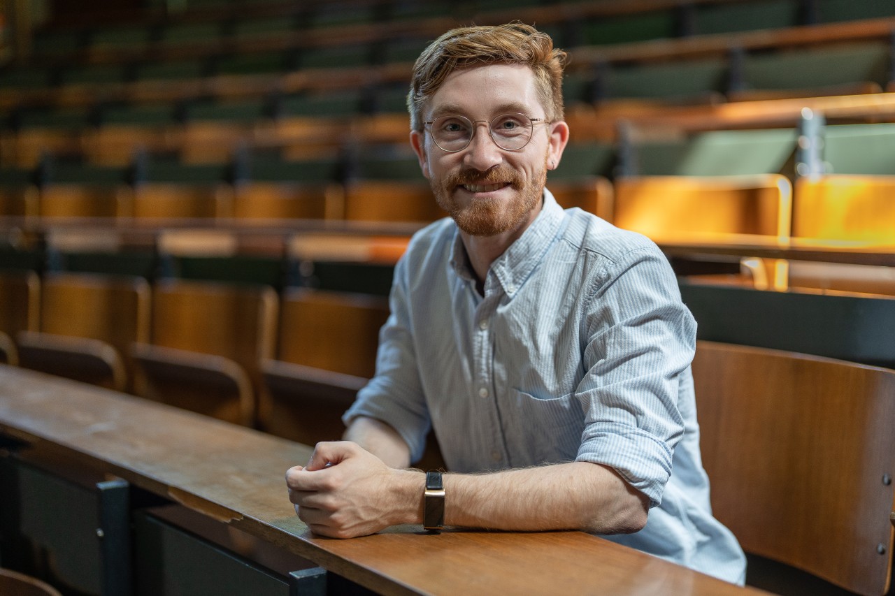 Man sitting in an empty university auditorium.