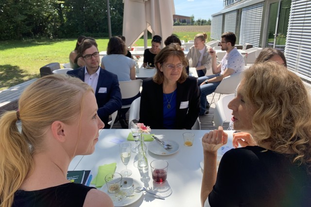 Event participants having lunch and networking while sitting at tables.