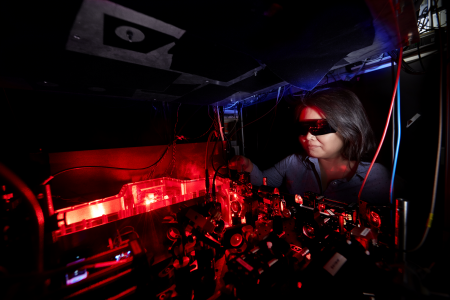 Female researcher working on a laser table top.