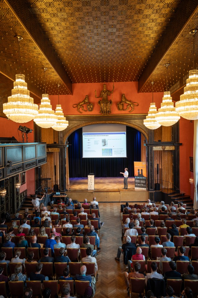 Audience sitting in aneorenaissance hall for a public talk on quantum computing. 