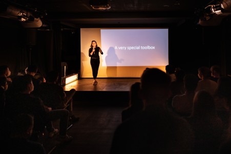 Female scientists on stage presenting a science slam in front of a audience.