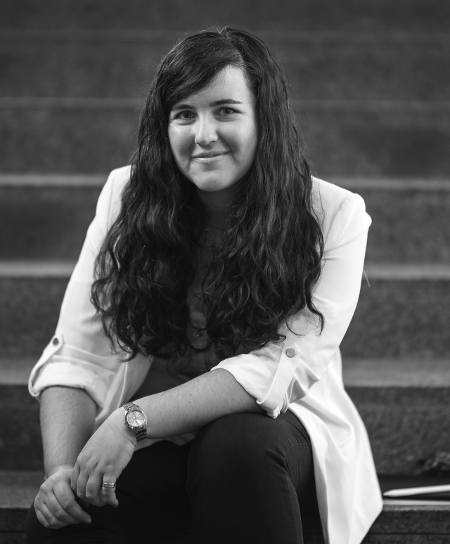 Ángela Capel siiting on the stairs of the LMU Physics foyer. 