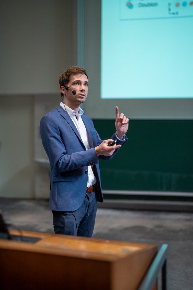 Man offering a presentation in a big lecture hall. 
