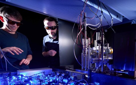 Prof. Johannes Zeiher (left) in the laboratory with typical setups for a quantum simulation experiment,