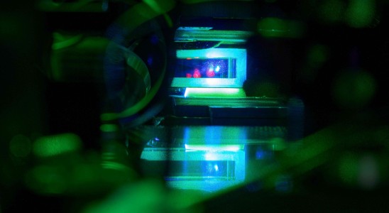 The image shows a so-called magneto-optical trap, in which a cold cloud of atoms is trapped in a glass cell.