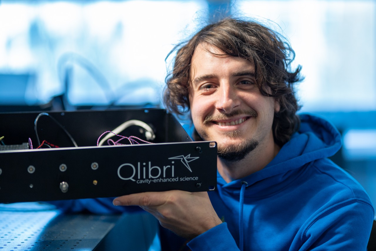 Jonathan Noé holding the Qlibri Cavity QED. Jonathan Noé smiling and holding one of the products made by his start-up, Qlibri.