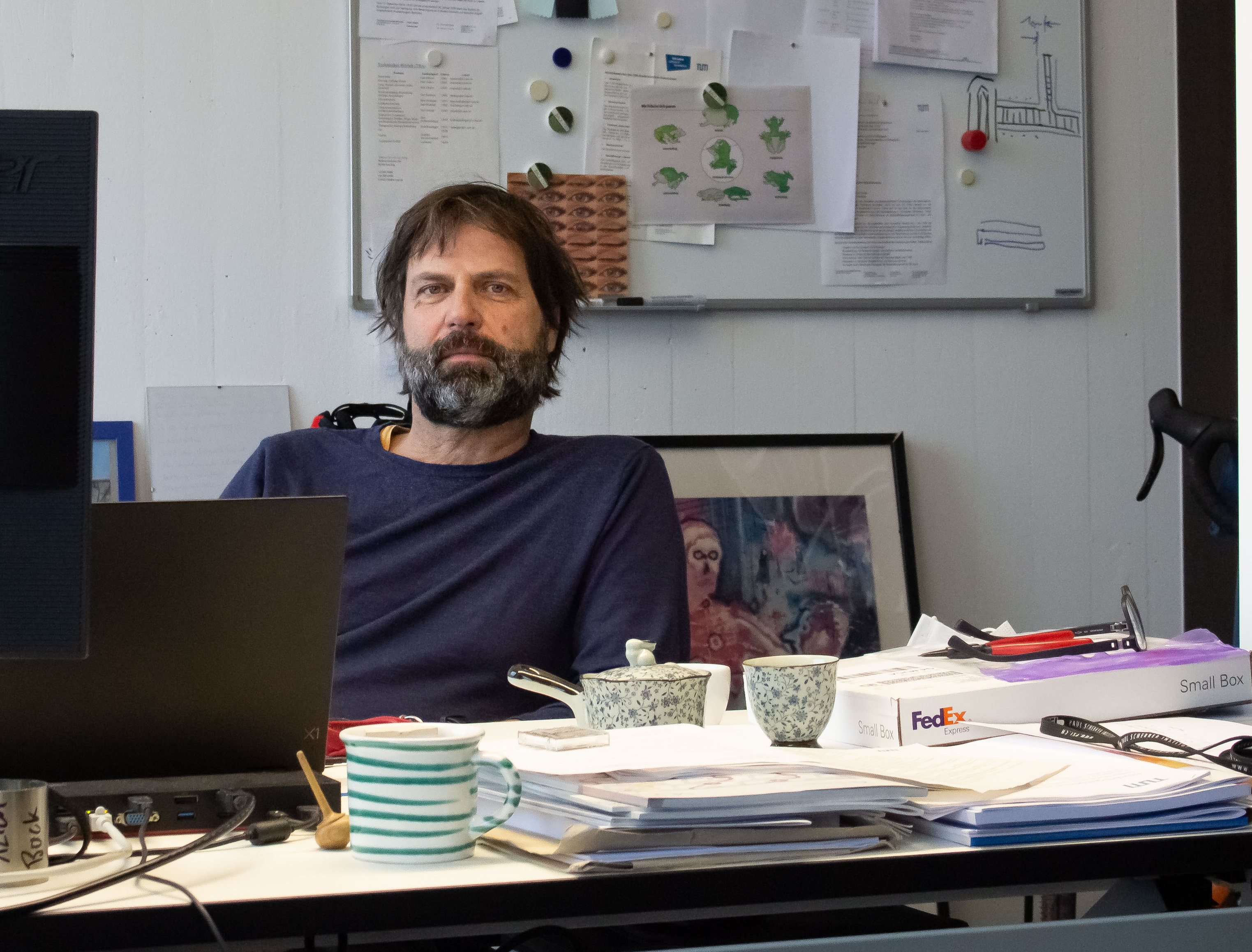 Christian Back sitting at his desk in front of a computer in his office. 