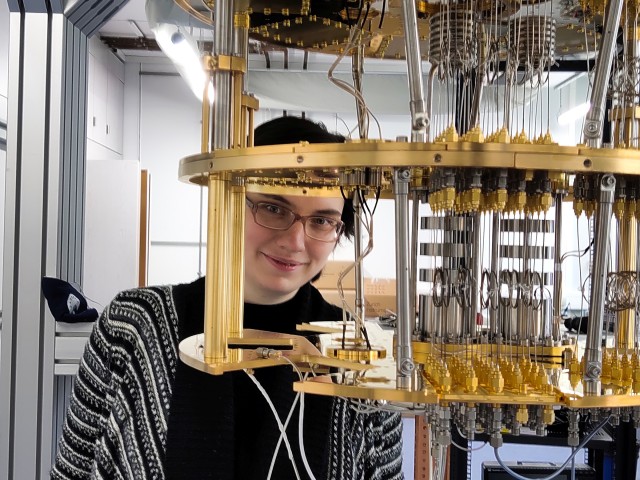 Nadezhda Kukharchyk in her laboratory standing behind an open cryostat.