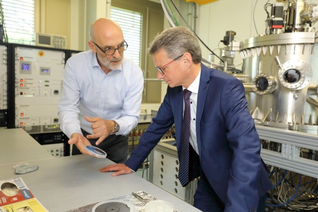 Rudolf Gross (left) of WMI shows a quantum chip to State Minister Sibler (right) in one of the WMI thin film labs.