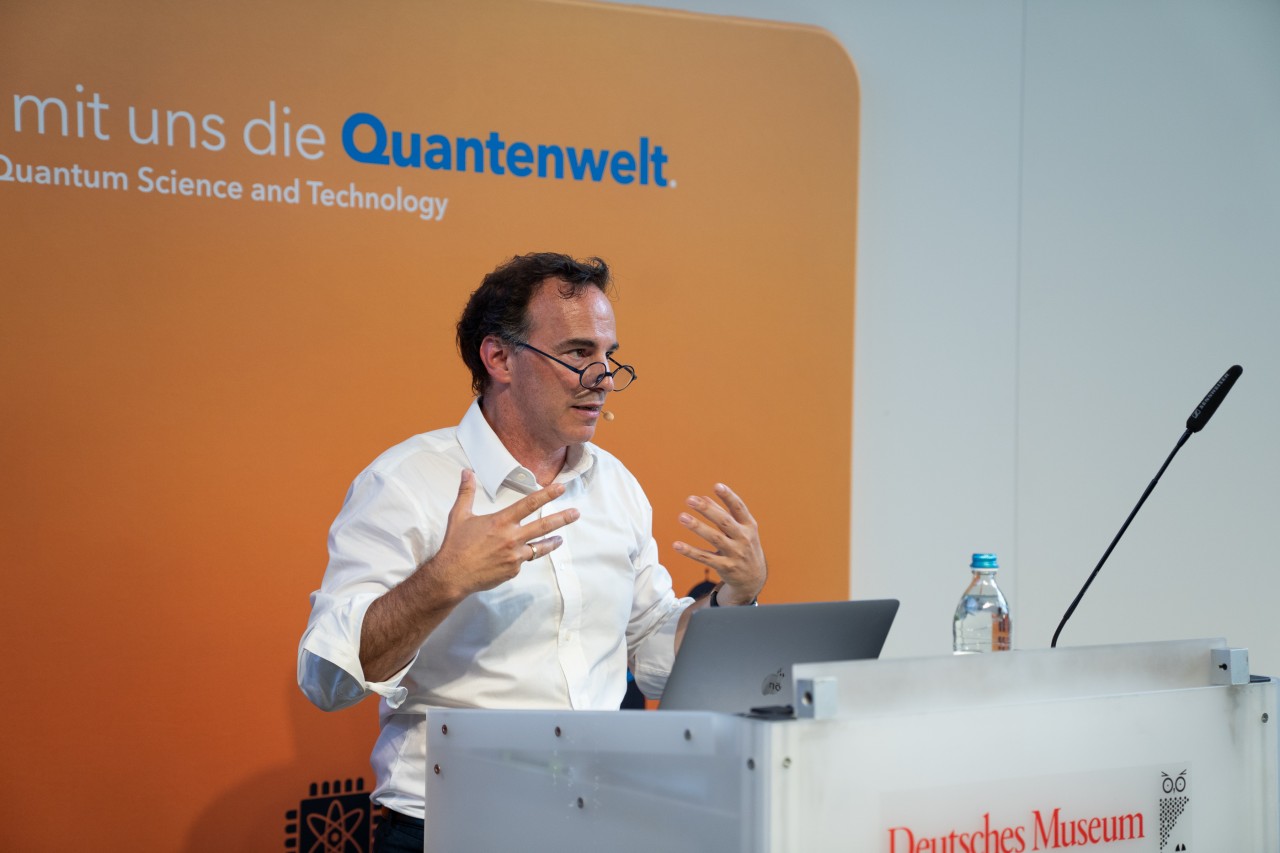 Markus Aspelmeyer giving a public talk at the Deutsches Museum in front of a full auditorium.